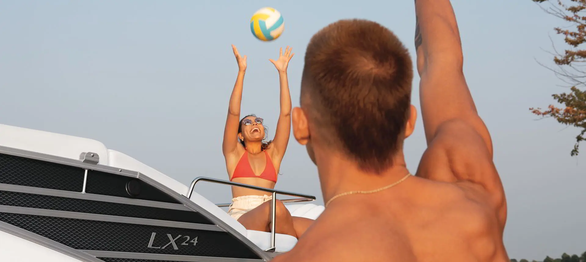 people playing with a volleyball on a bennington LX sport pontoon boat