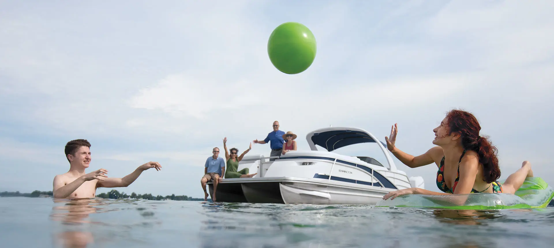 kids playing with a ball in front of a bennington q pontoon boat
