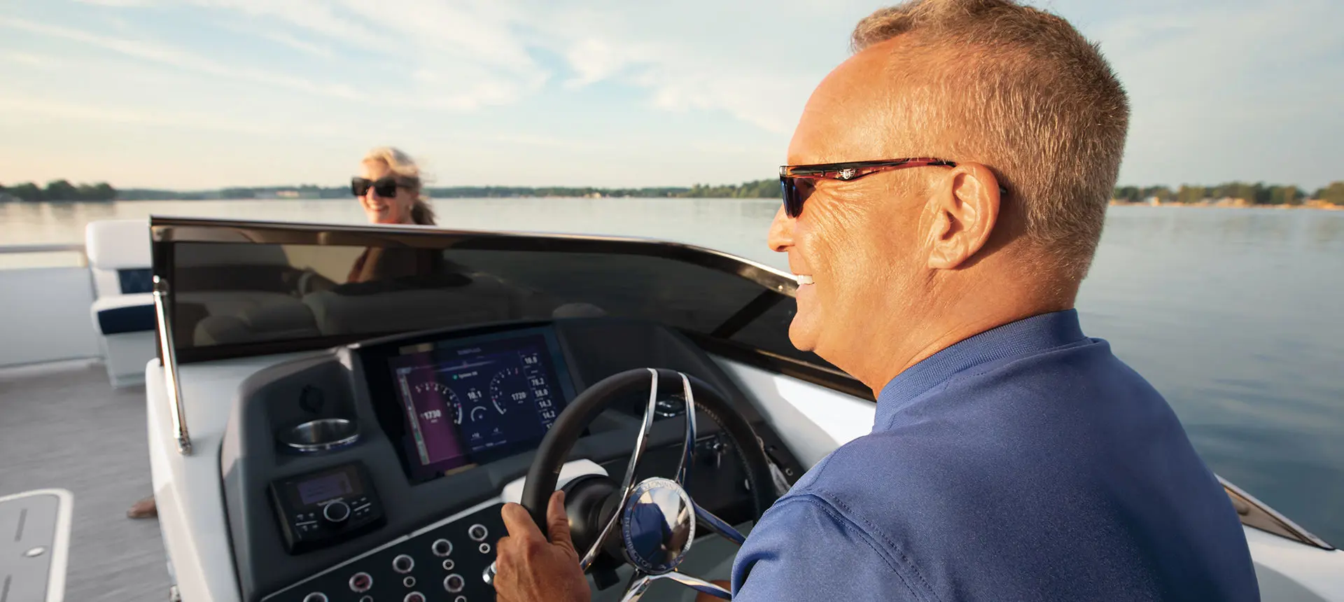 man smiling at the helm of a bennington q pontoon boat