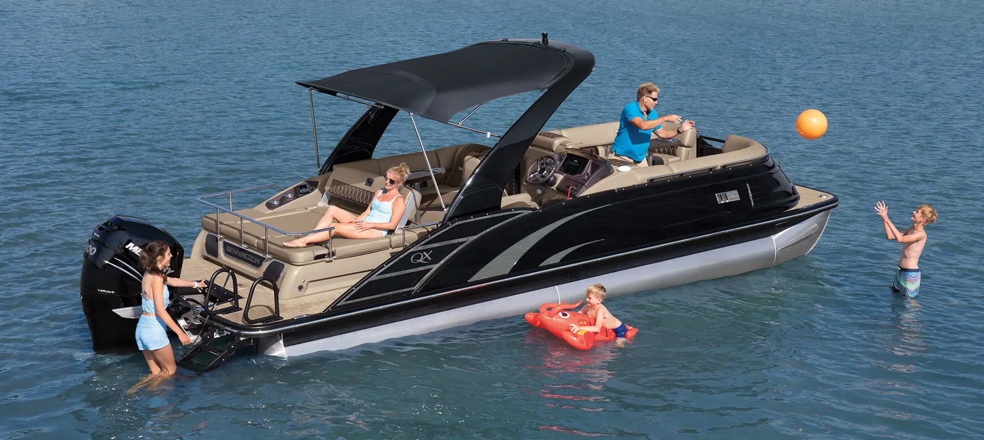 kids playing around a Bennington QX pontoon boat in the water
