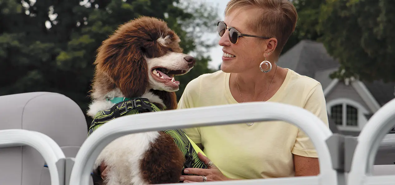 woman smiling at her dog on a Bennington SV pontoon boat