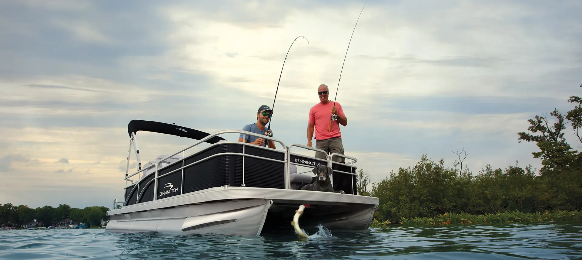 2 men catching fish on the bow of a Bennington SV pontoon boat