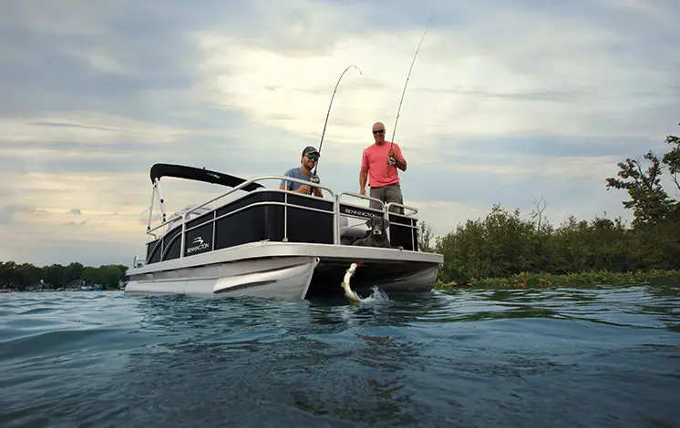 2 men catching fish on the bow of a Bennington SV pontoon boat