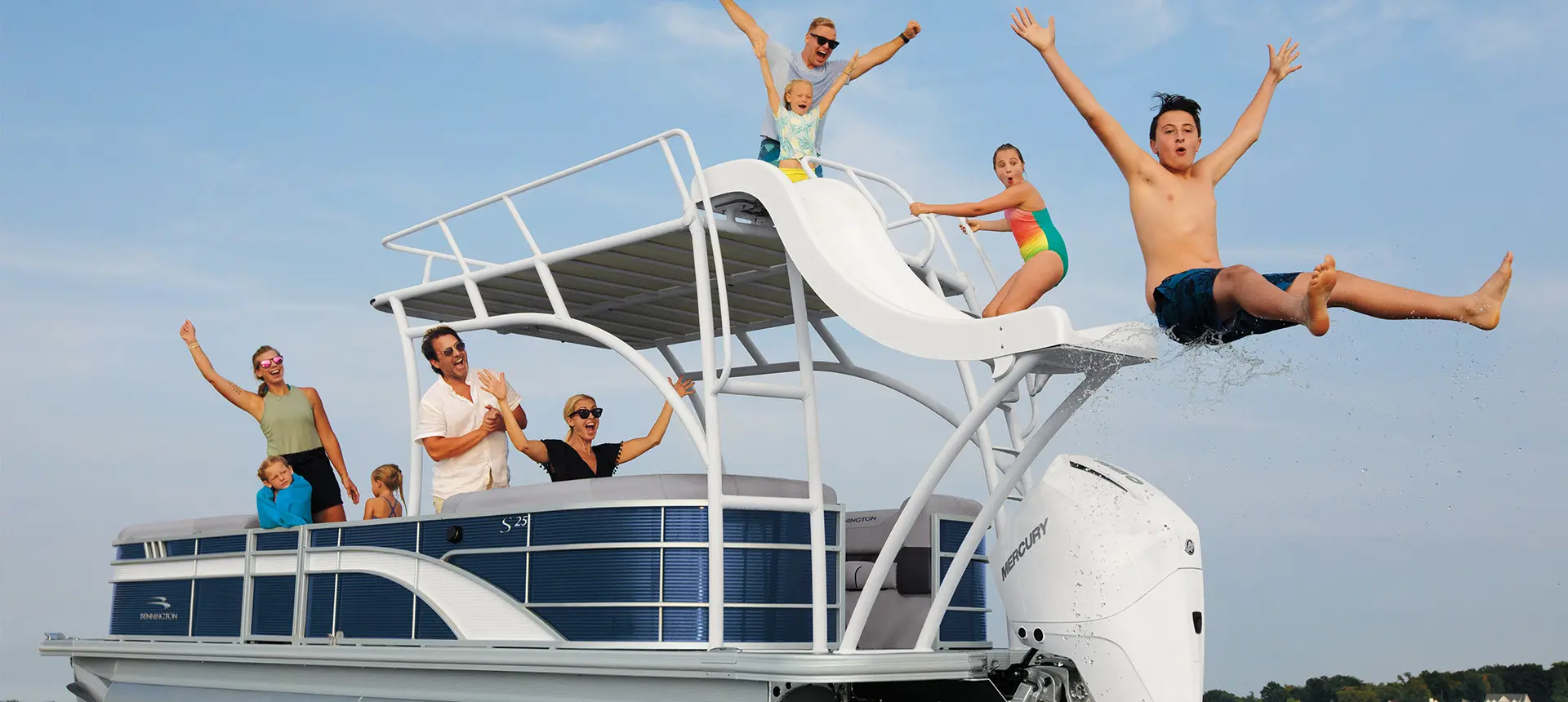 boy using the slide on a bennington sx pontoon boat