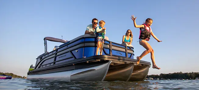 kid jumping off the bow into the water on a bennington s series pontoon