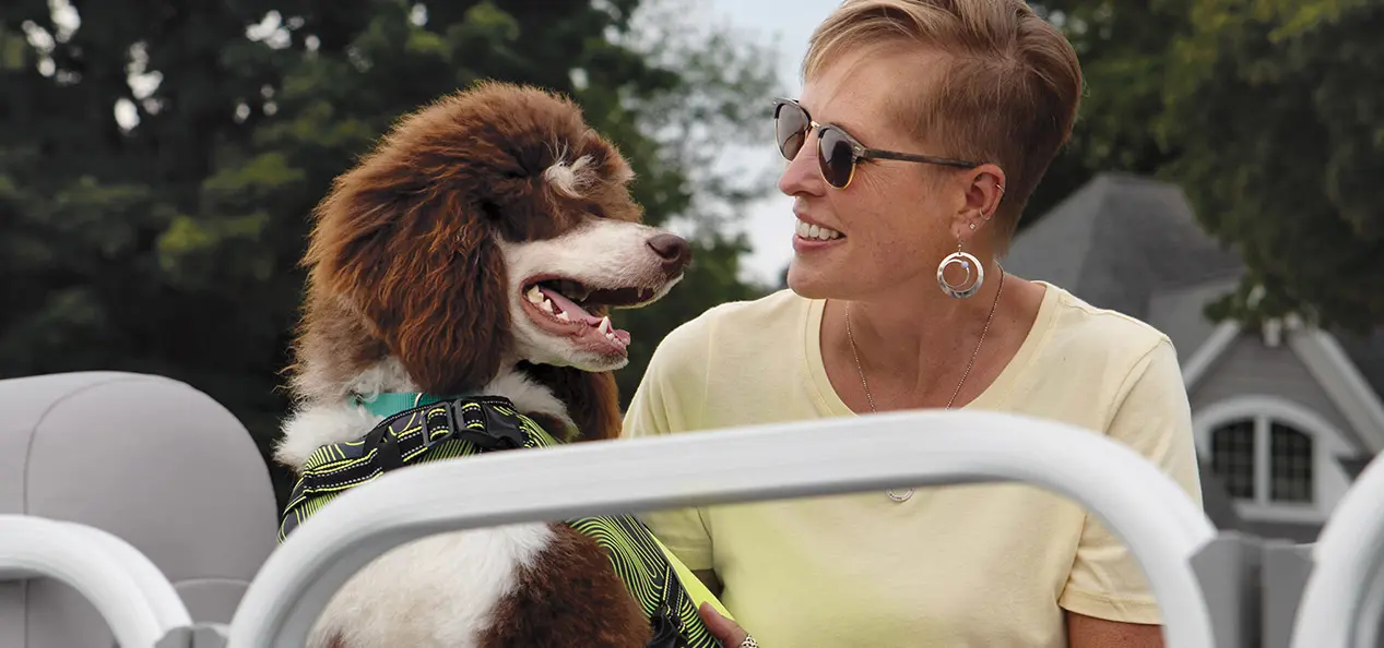 woman smiling at her dog on a Bennington SV pontoon boat