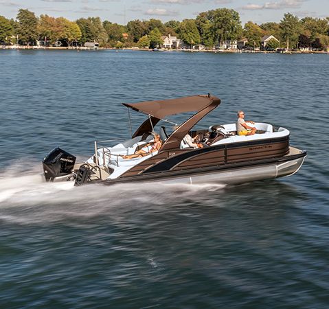 Side profile of a Bennington cruising pontoon on a lake.