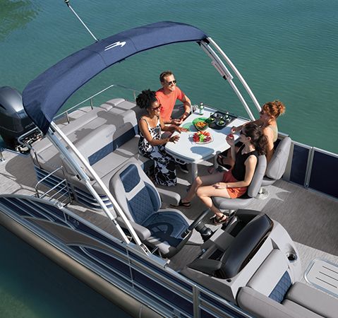 Aerial view of 4 people sitting at the stern table on a Bennington entertainment pontoon.