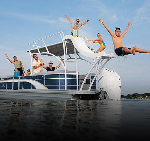 Kids enjoying the pontoon slide on a Bennington pontoon boat with the top deck layout.