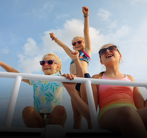 Kids enjoying the sun deck on a Bennington pontoon boat with the top deck layout.