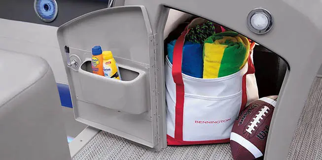 Integrated storage under the captain's helm of a Bennington L Bowrider Line pontoon boat.