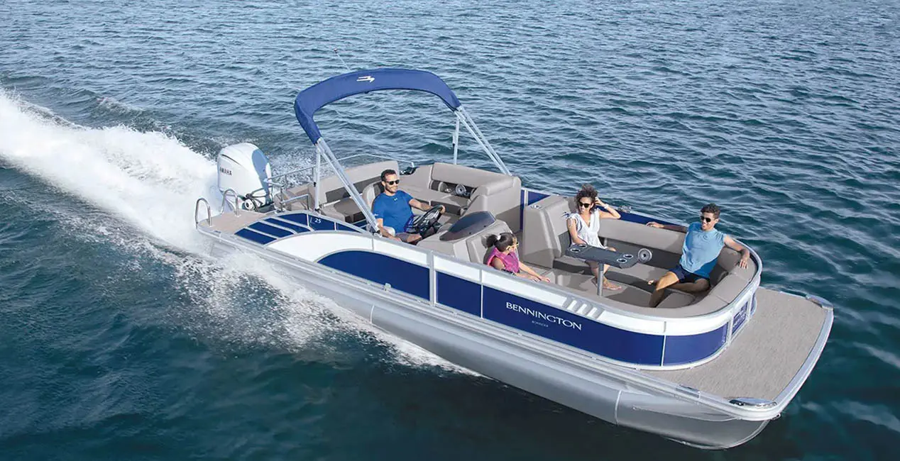 Aerial view of a Bennington L Bowrider Line pontoon boat cruising across a lake.