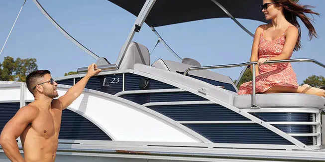 Man talking to a woman who's sitting on the Swingback seat on a Bennington L Bowrider Line pontoon boat.