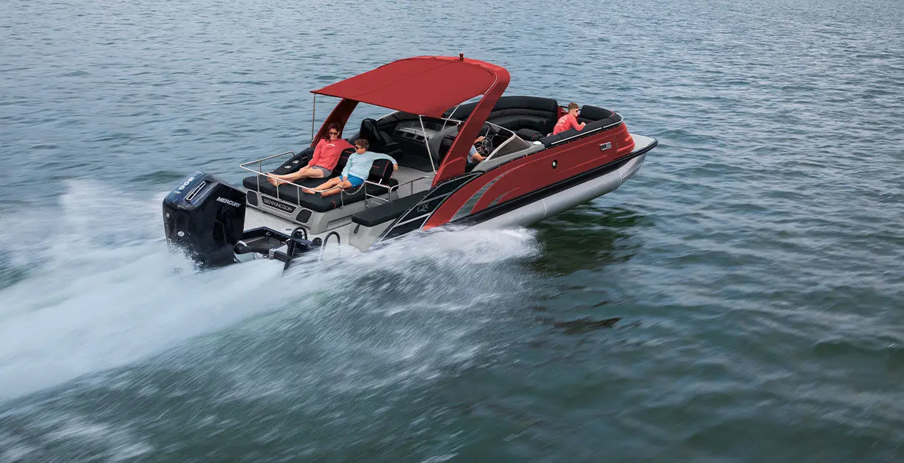 Aerial view of a Bennington QX Line pontoon boat with swingback layout cruising across a lake.