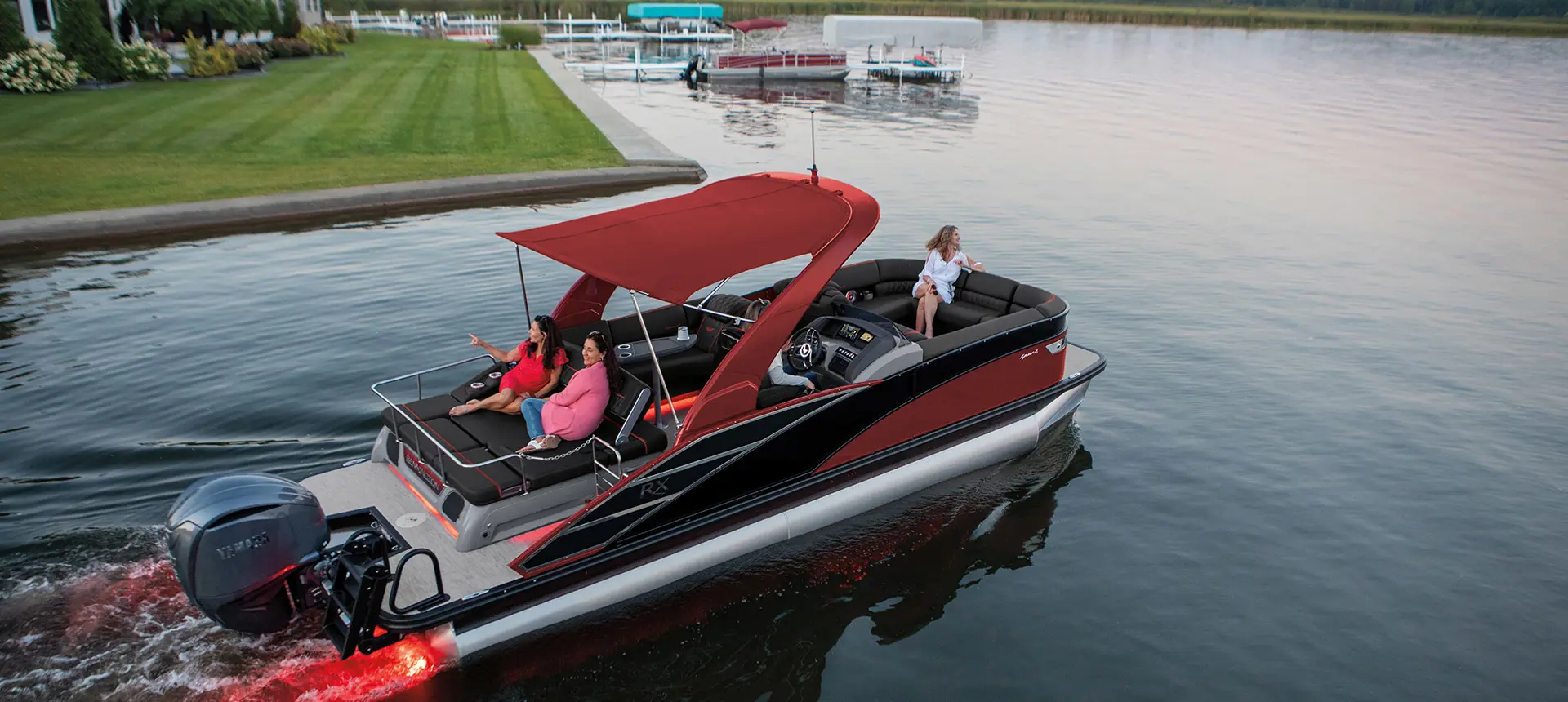 Aerial view of a Bennington RX Sport pontoon boat cruising near shore.