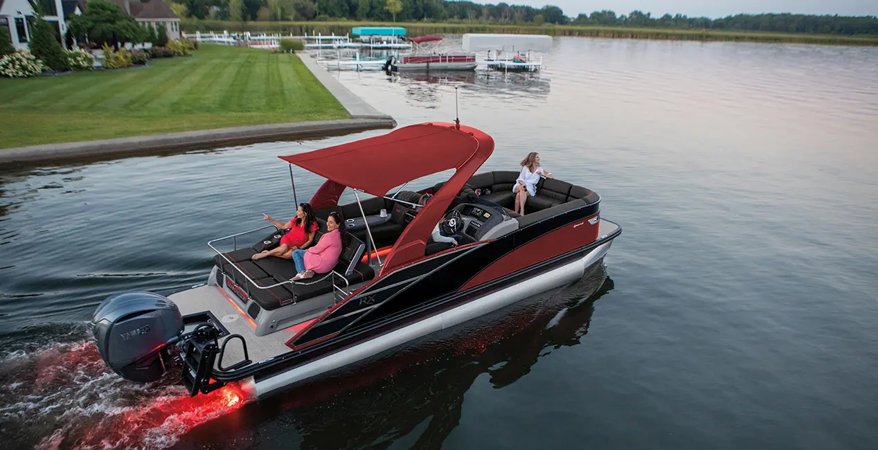Aerial view of a Bennington RX Sport pontoon boat cruising near shore.