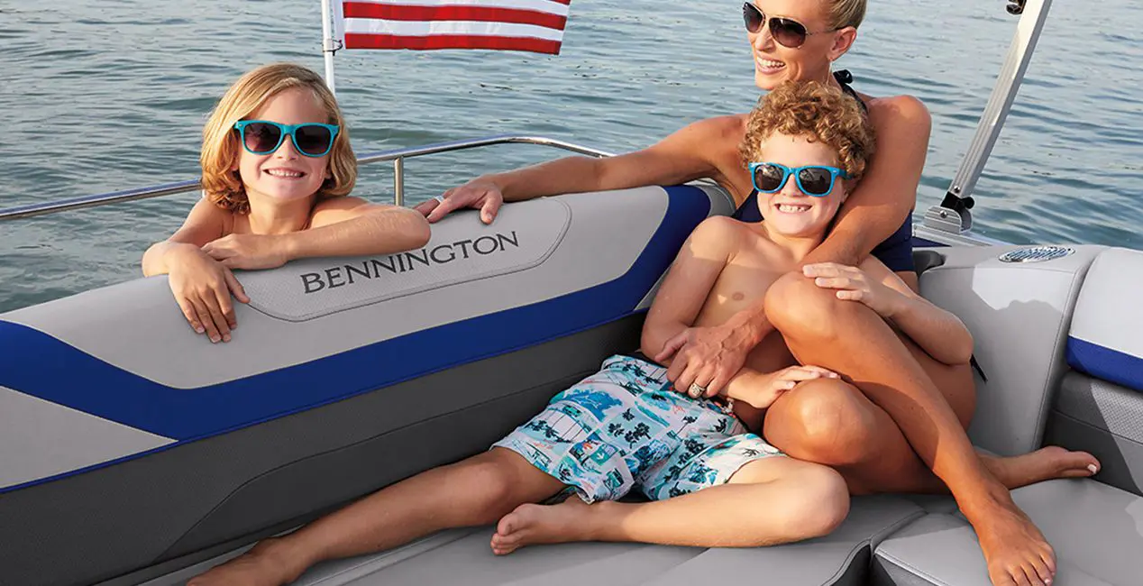 Family relaxing comfortable on the stern L-bench seat on a Bennington SX Line pontoon boat with L-Bench layout.