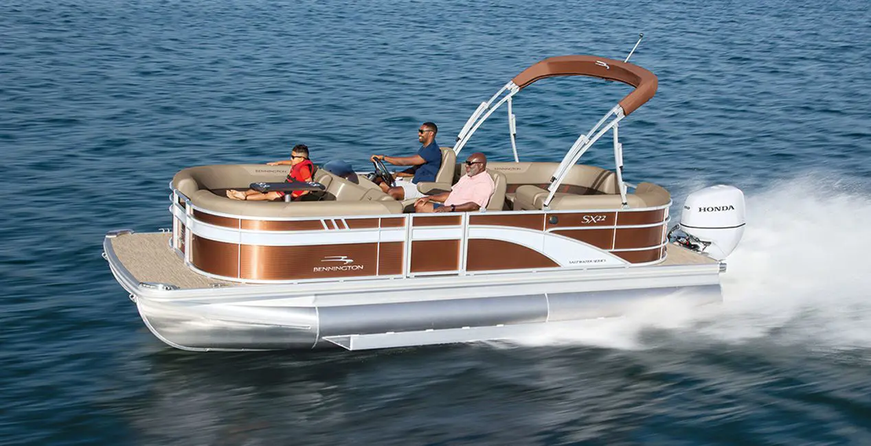 Side profile of a 22-foot Bennington SX Line pontoon boat cruising across a lake.