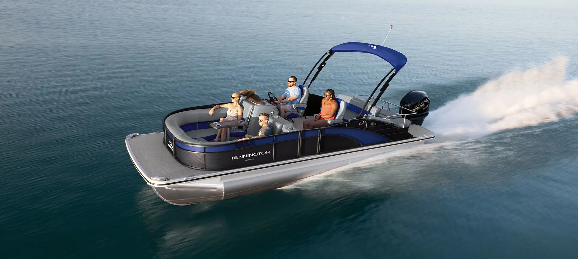 Aerial view of a Bennington Bowrider pontoon boat cruising across a lake.