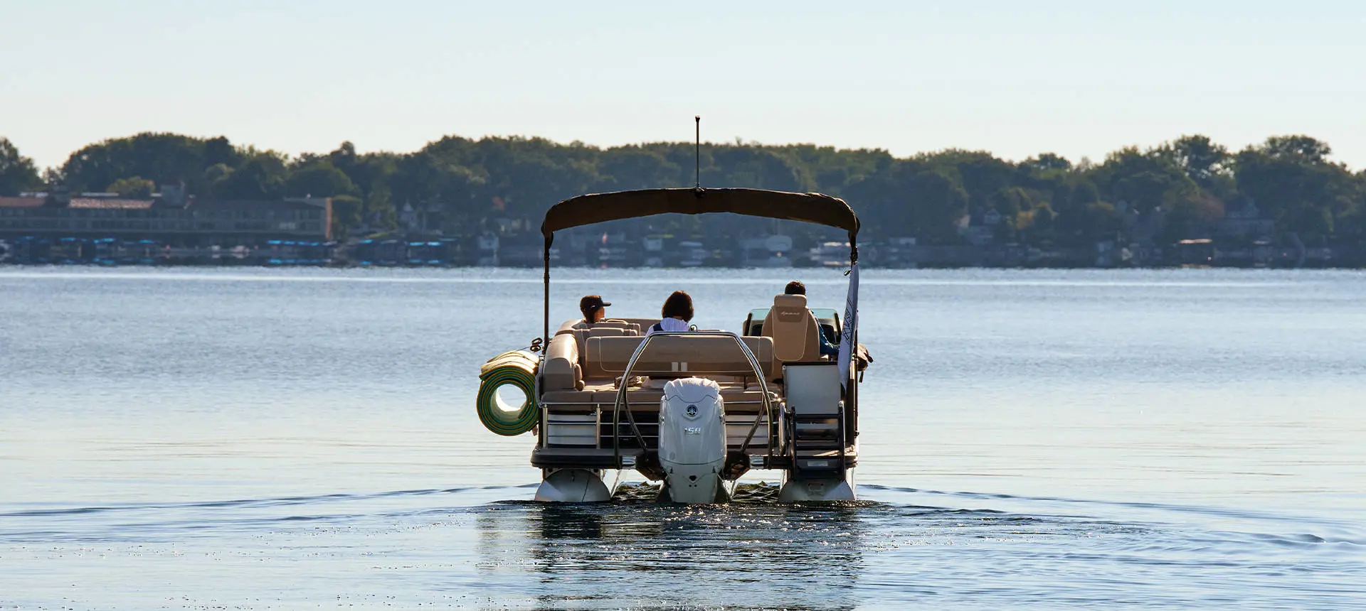 Rear view view of a pontoon boat with lily pad attached to the side using a toolless boat attachment system.