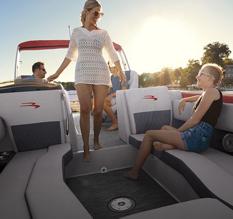 Women stepping into the signature step-down U-Lounge on a Bennington L Series pontoon.