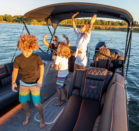 A family jamming to music on their Bennington entertainment/party pontoon boat that features a Rockford Fosgate audio system.