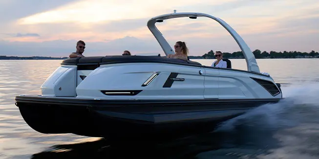 4 people enjoying a lake cruise on a Bennington QX line pontoon boat.