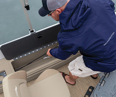 Man putting rod in rod locker on a Bennington S One Pontoon Boat. 