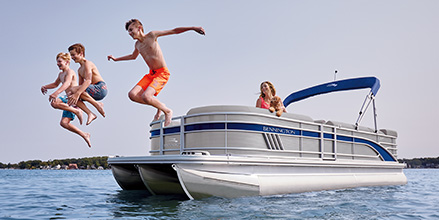 Kids jumping off of a Bennington pontoon