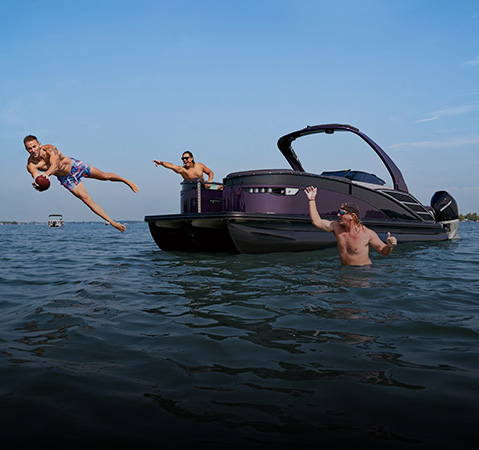 Friends playing with football off the back of a Bennington pontoon. 