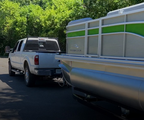 Truck pulling a Bennington pontoon on a trailer. 