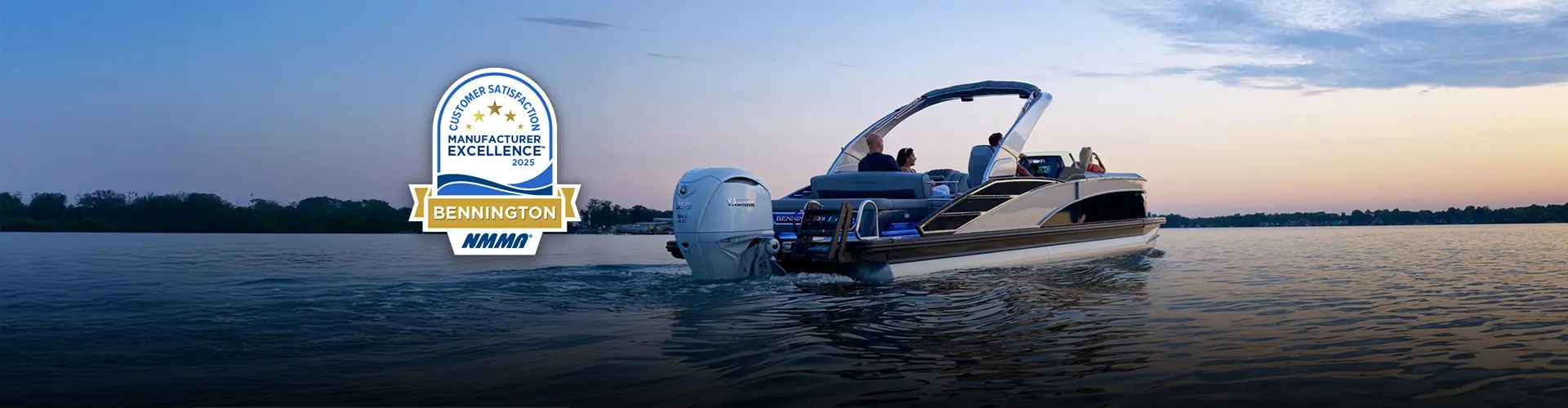 A luxury Bennington pontoon boat cruising on a lake at sunset, featuring the 2025 NMMA Manufacturer Excellence award seal.
