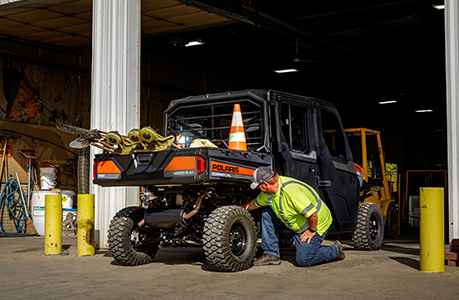Man checking the oil on a Polaris Commercial Pro XD work UTV.