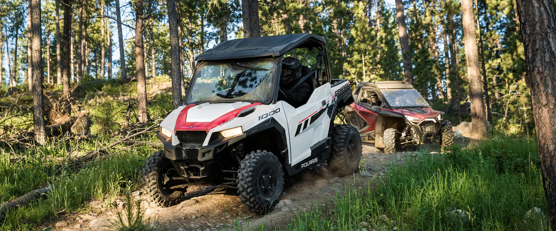 Two Polaris General 1000 in a trail road