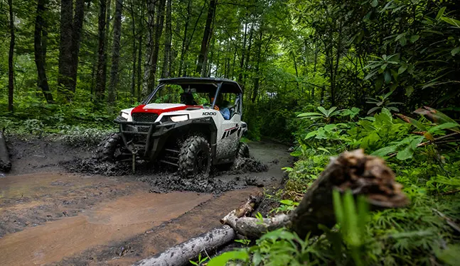 A Polaris GENERAL 1000 riding a muddy road
