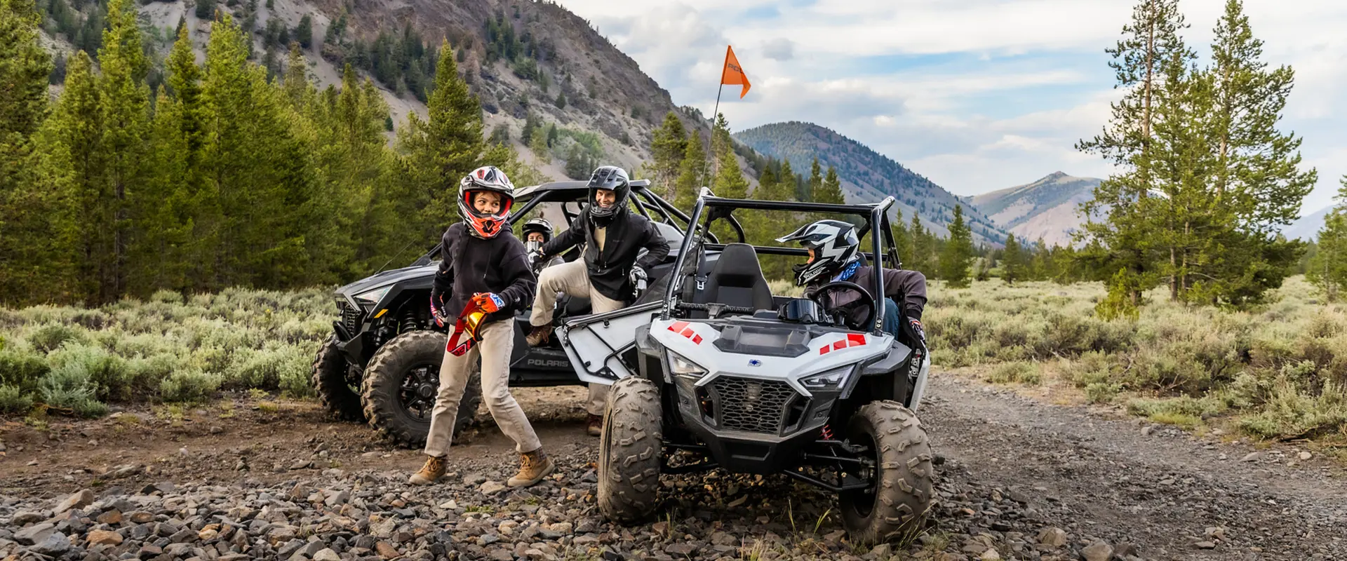2 kids standing next to RZR 200