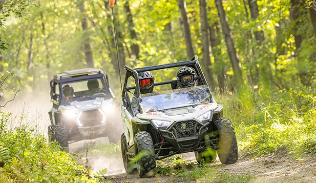 2 kids riding RZR 200