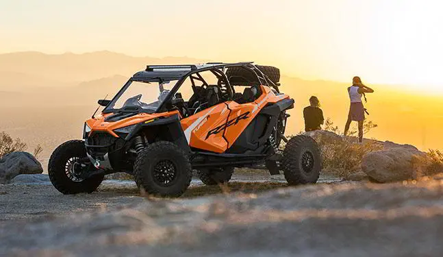 man and a woman overlooking a cliff with their RZR TURBO R