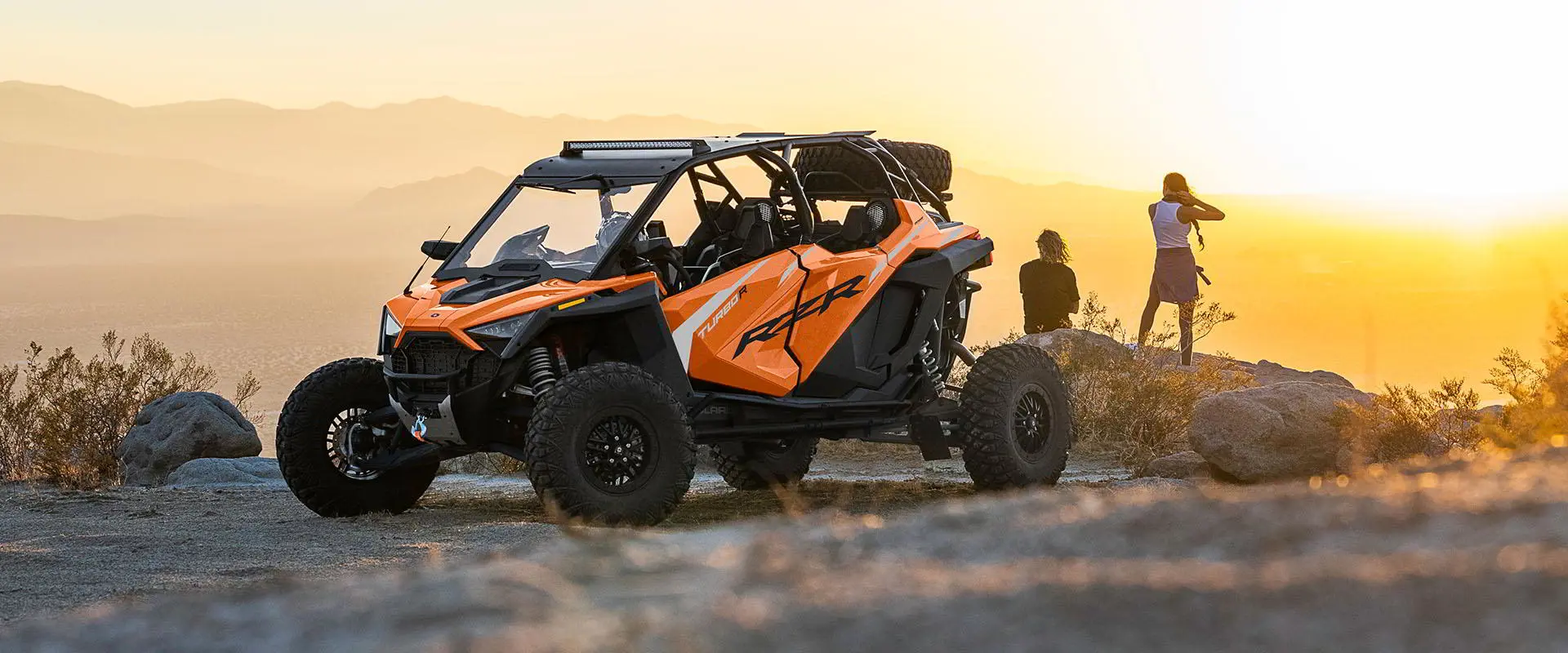 man and a woman overlooking a cliff with their RZR TURBO R