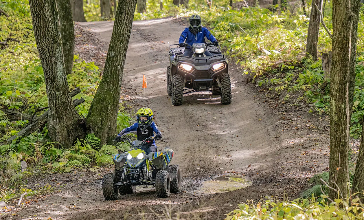 two kids riding an outlaw 110