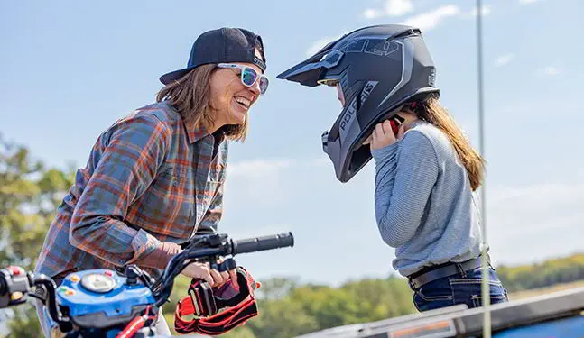 Maman souriant à sa fille après une randonnée dans son VTT pour jeunes Polaris Sportsman 110 2025.