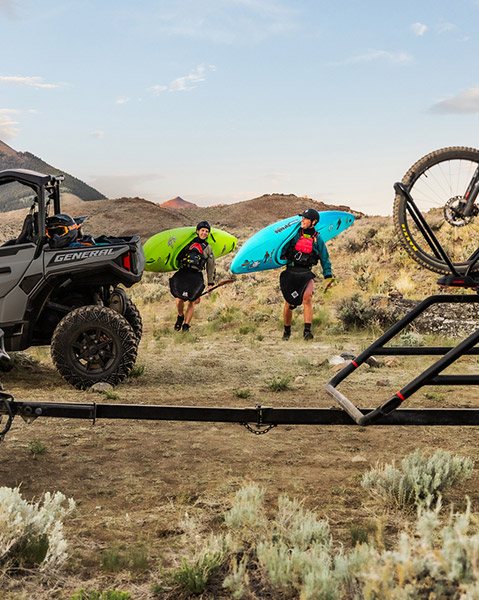 Two Off-Road riders walking toward their Polaris General vehicles