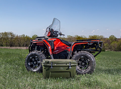 Side view of Polaris Sportsman next to Nortstar cooler