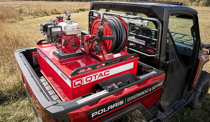 Close-up of a Polaris Government & Defense UTV, showcasing a Q-TAC firefighting module with a red water tank, and hose reel system.