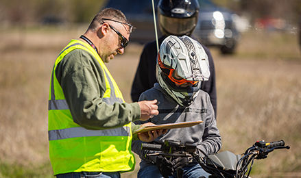 4-H volunteer reviewing paperwork with a child during an ATV safety training.