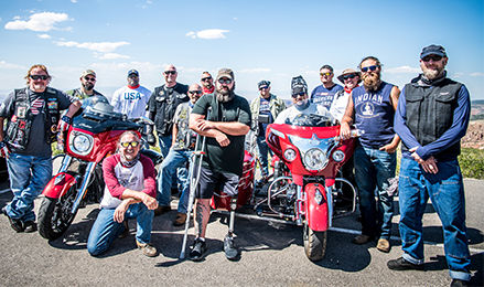 Group of veterans with Indian Motorcycles at a scenic overlook.