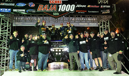 Polaris RZR Factory Racing team celebrating their victory at the 58th Baja 1000 race.
