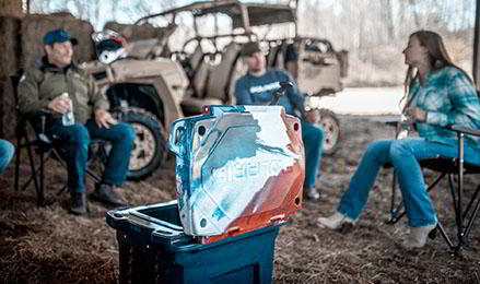 Three friends talking around the Limited Edition Patriot Northstar Cooler of Polaris