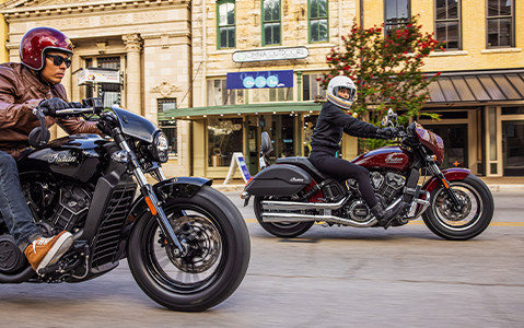 Two people riding a couple of Indian Motorcycles on the road