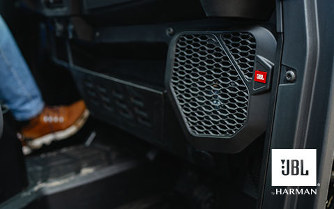 Close-up of a JBL speaker accessory in a Polaris vehicle interior.